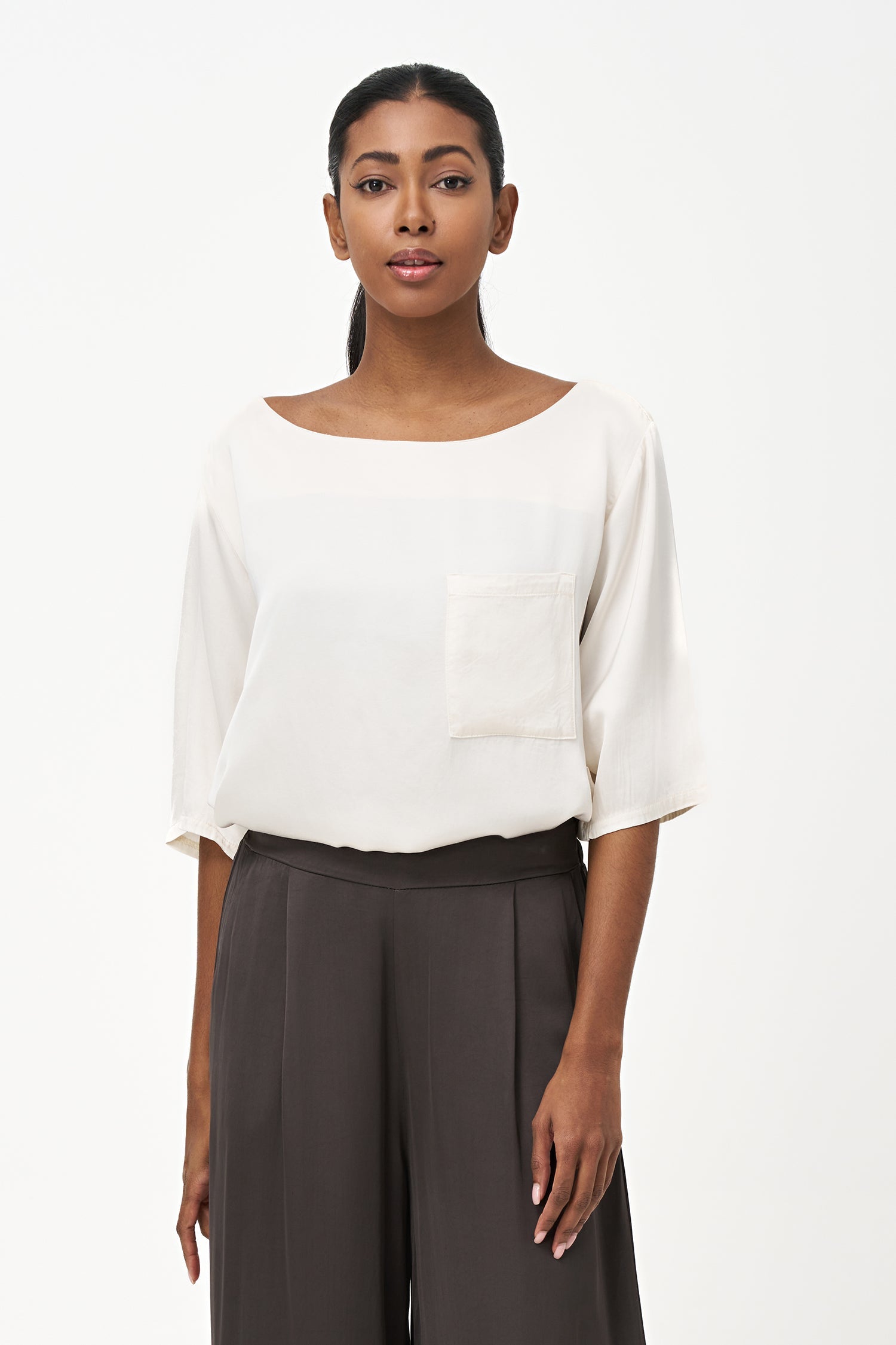 Women’s woven boat-neck top, with elbow length sleeves and a pocket at the chest
