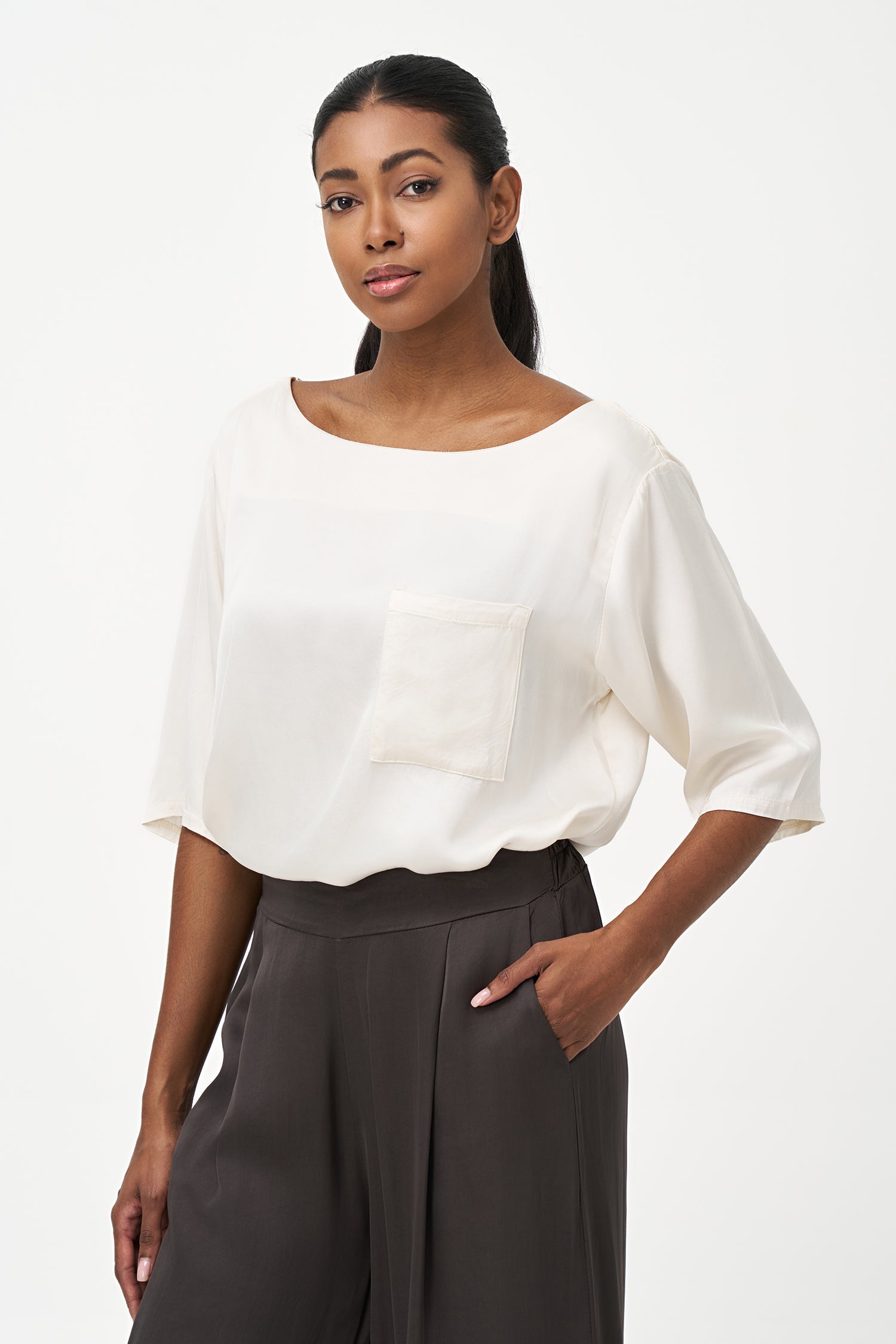 Women’s woven boat-neck top, with elbow length sleeves and a pocket at the chest