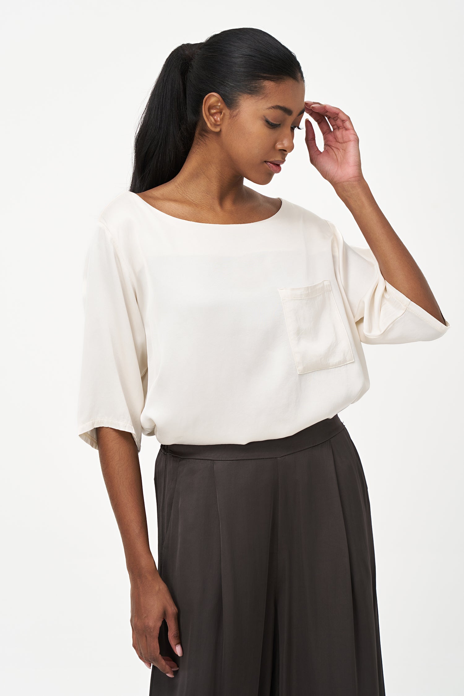 Women’s woven boat-neck top, with elbow length sleeves and a pocket at the chest