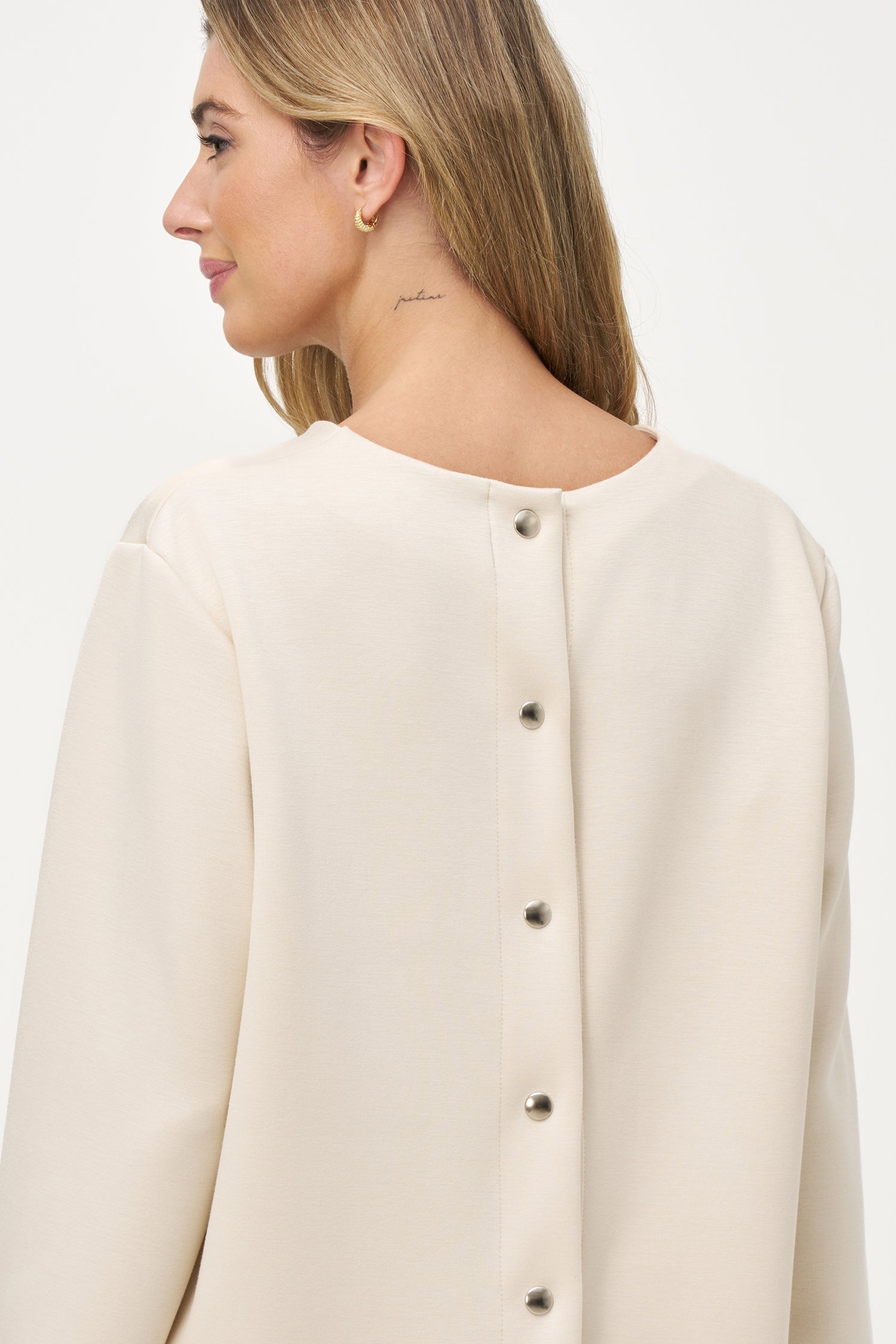 Women’s knit crew-neckline sweatshirt, with long sleeves and a snap-button closure system at the back