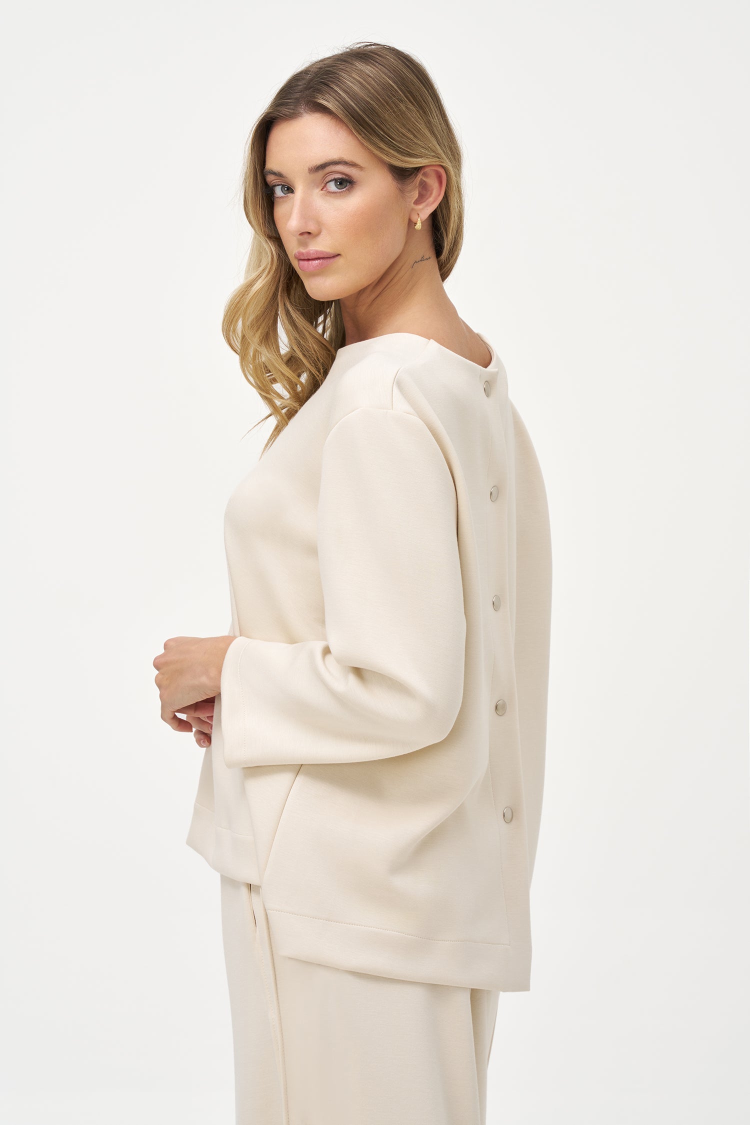 Women’s knit crew-neckline sweatshirt, with long sleeves and a snap-button closure system at the back