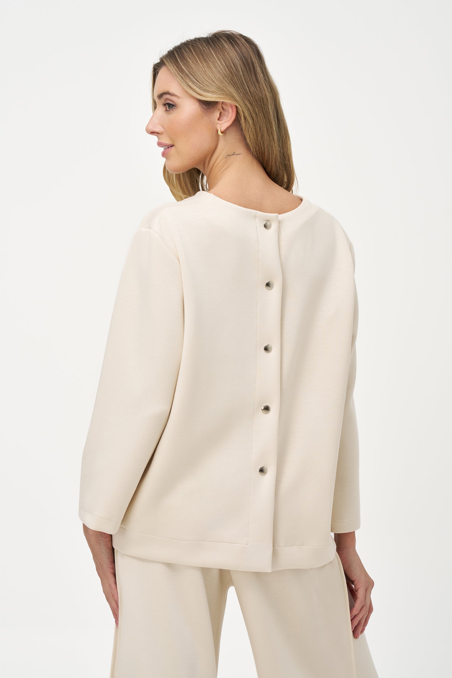 Women’s knit crew-neckline sweatshirt, with long sleeves and a snap-button closure system at the back