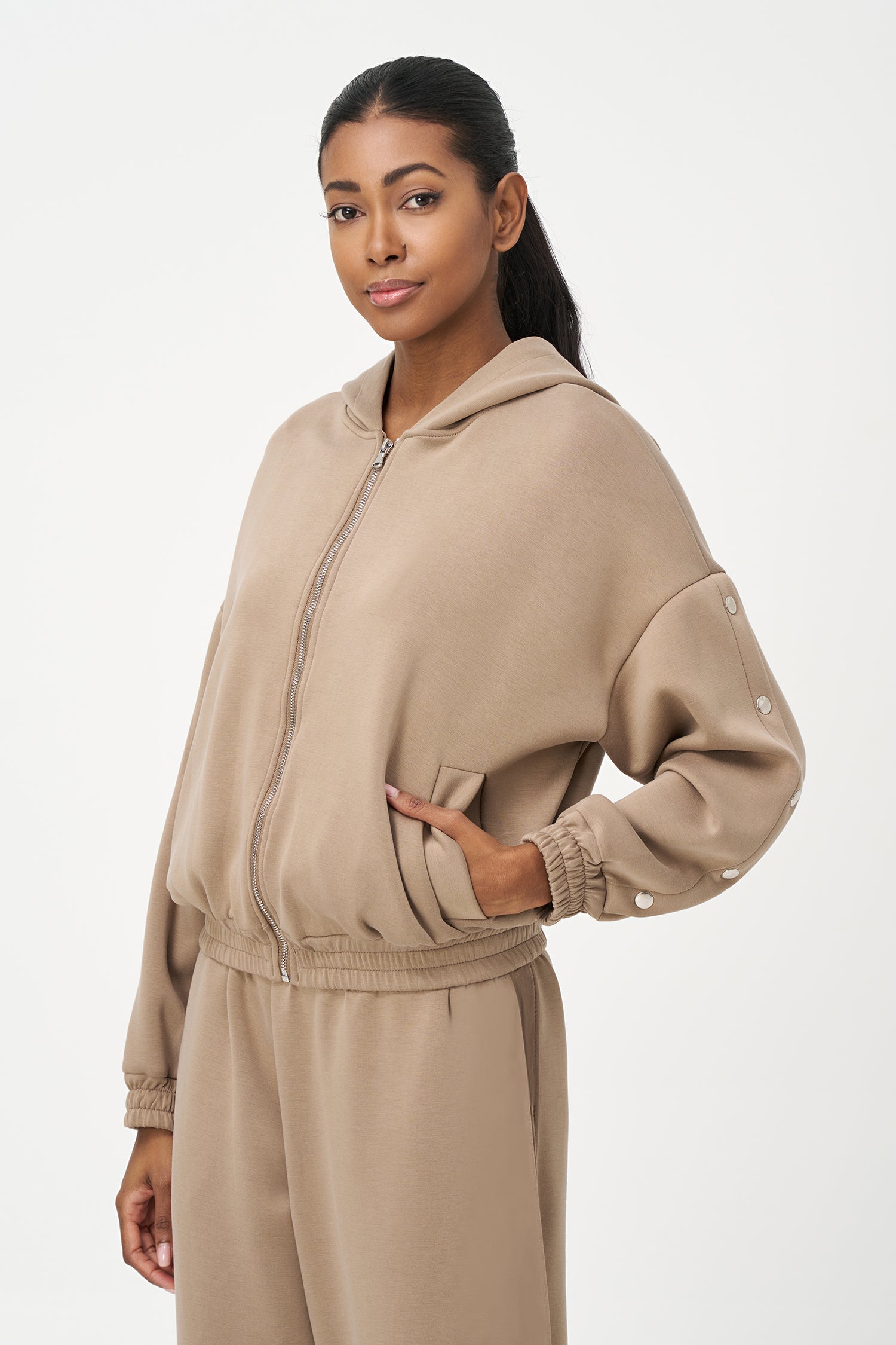 Women's knit hooded zip-up long sleeve sweatshirt, with stud detailing at the arms and front welt functional pockets