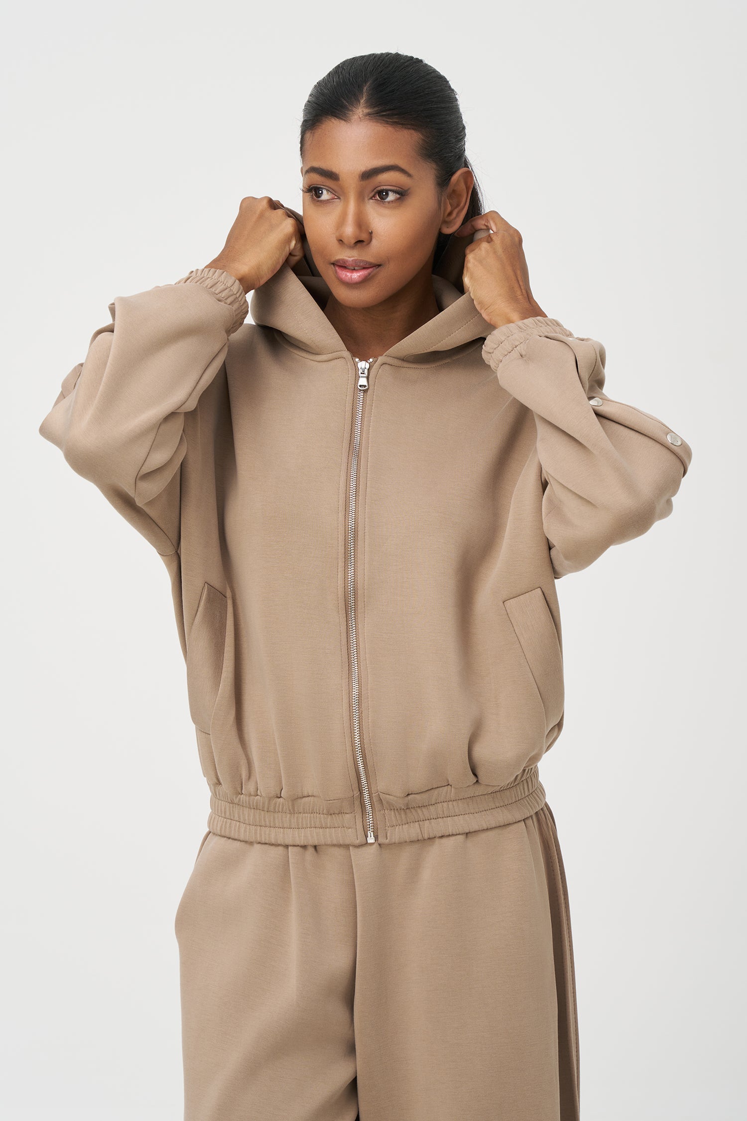 Women's knit hooded zip-up long sleeve sweatshirt, with stud detailing at the arms and front welt functional pockets