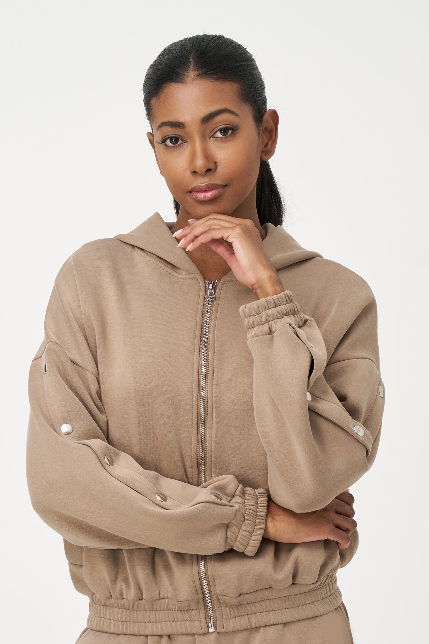 Women's knit hooded zip-up long sleeve sweatshirt, with stud detailing at the arms and front welt functional pockets