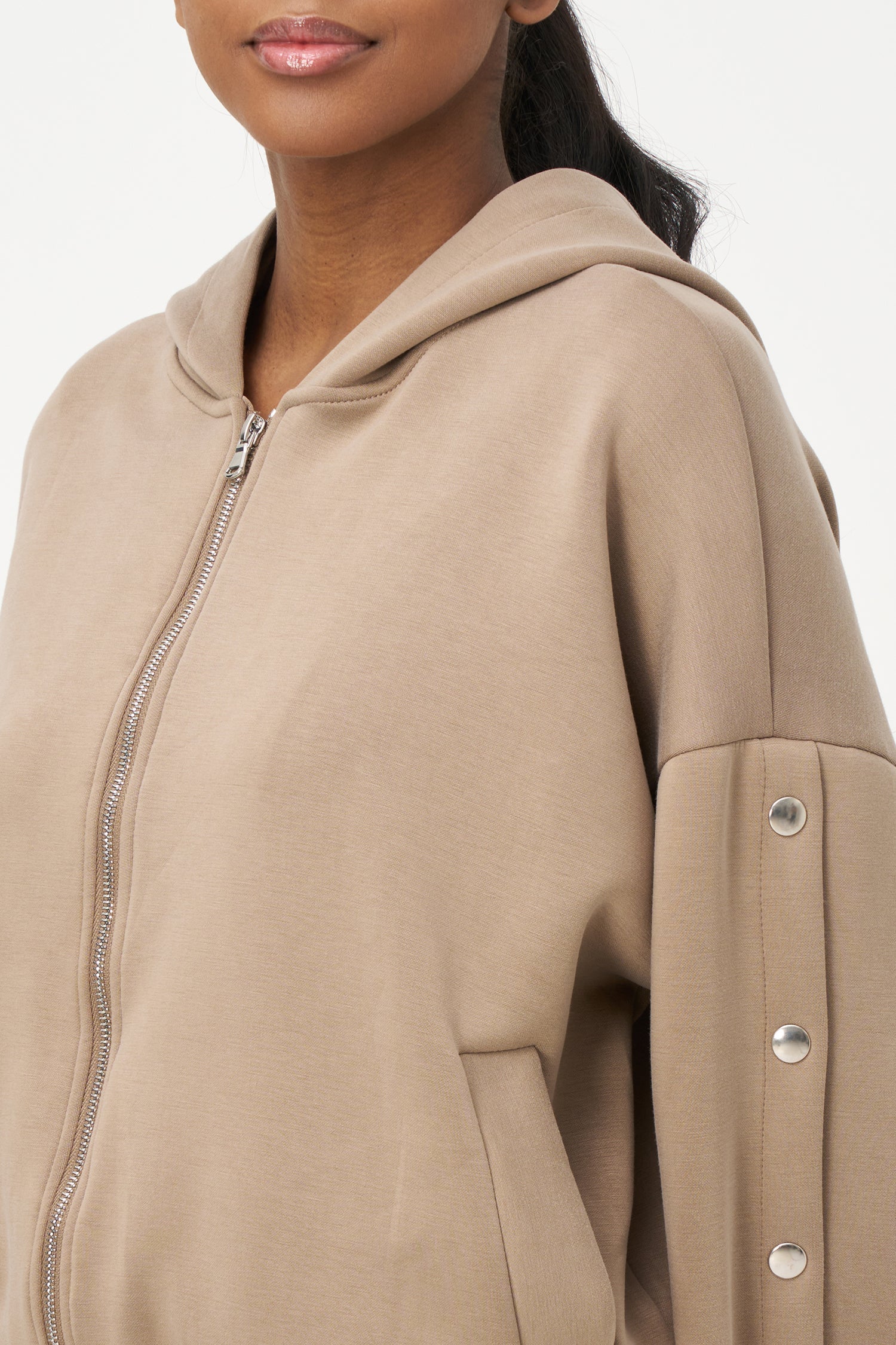 Women's knit hooded zip-up long sleeve sweatshirt, with stud detailing at the arms and front welt functional pockets