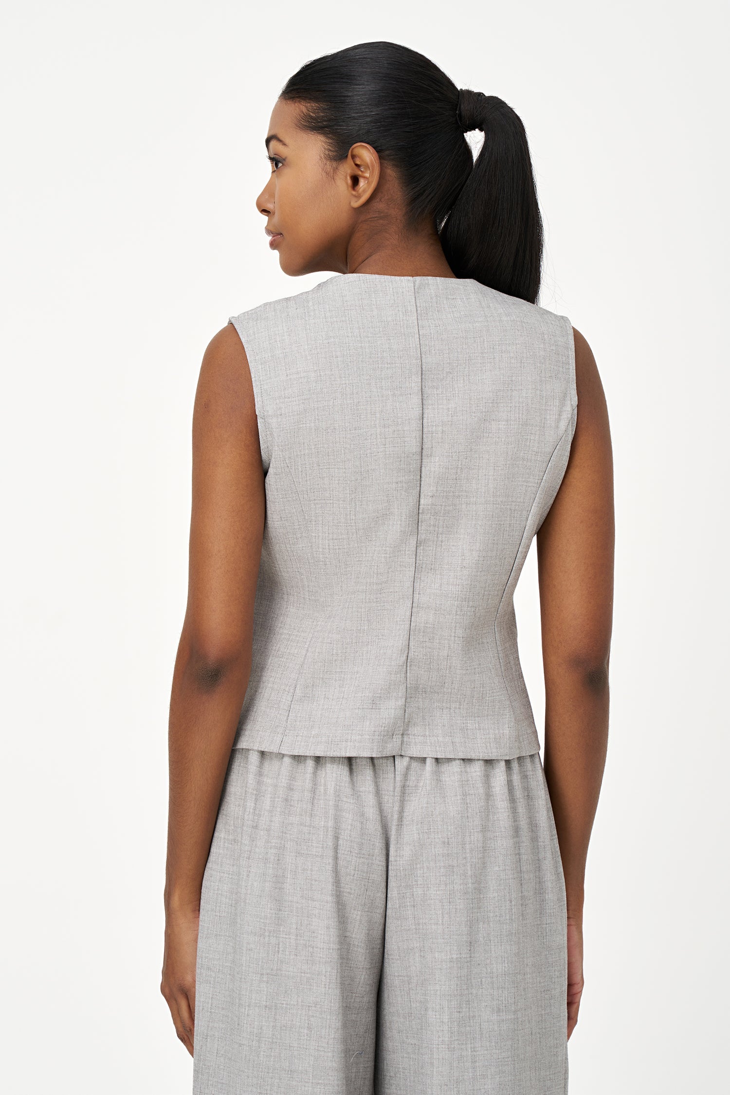 Women’s woven sleeveless vest with a v-neckline and a front button closure