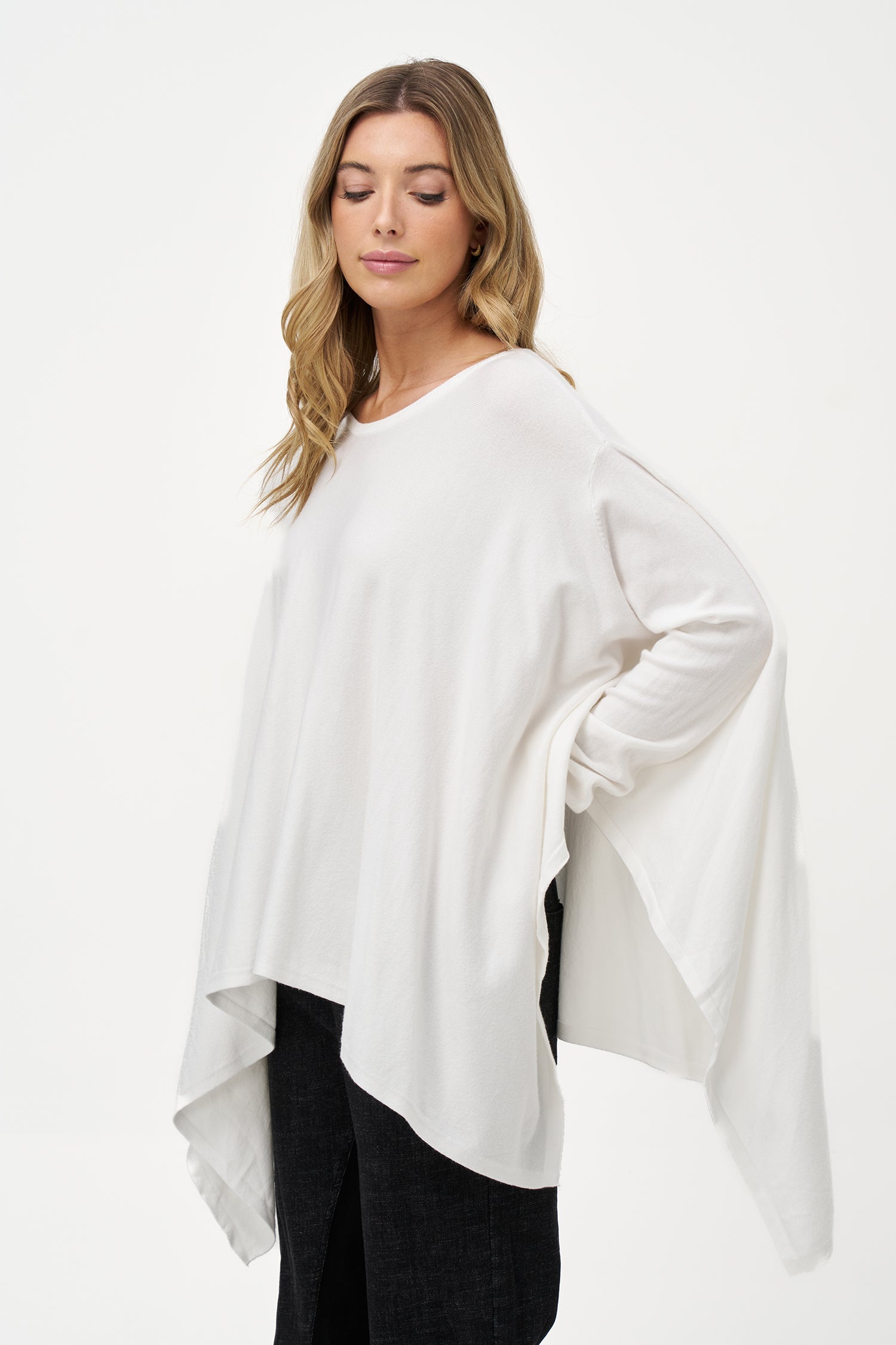 Women's knit oversized long sleeve wide-neck sweater, with an asymmetrical hem