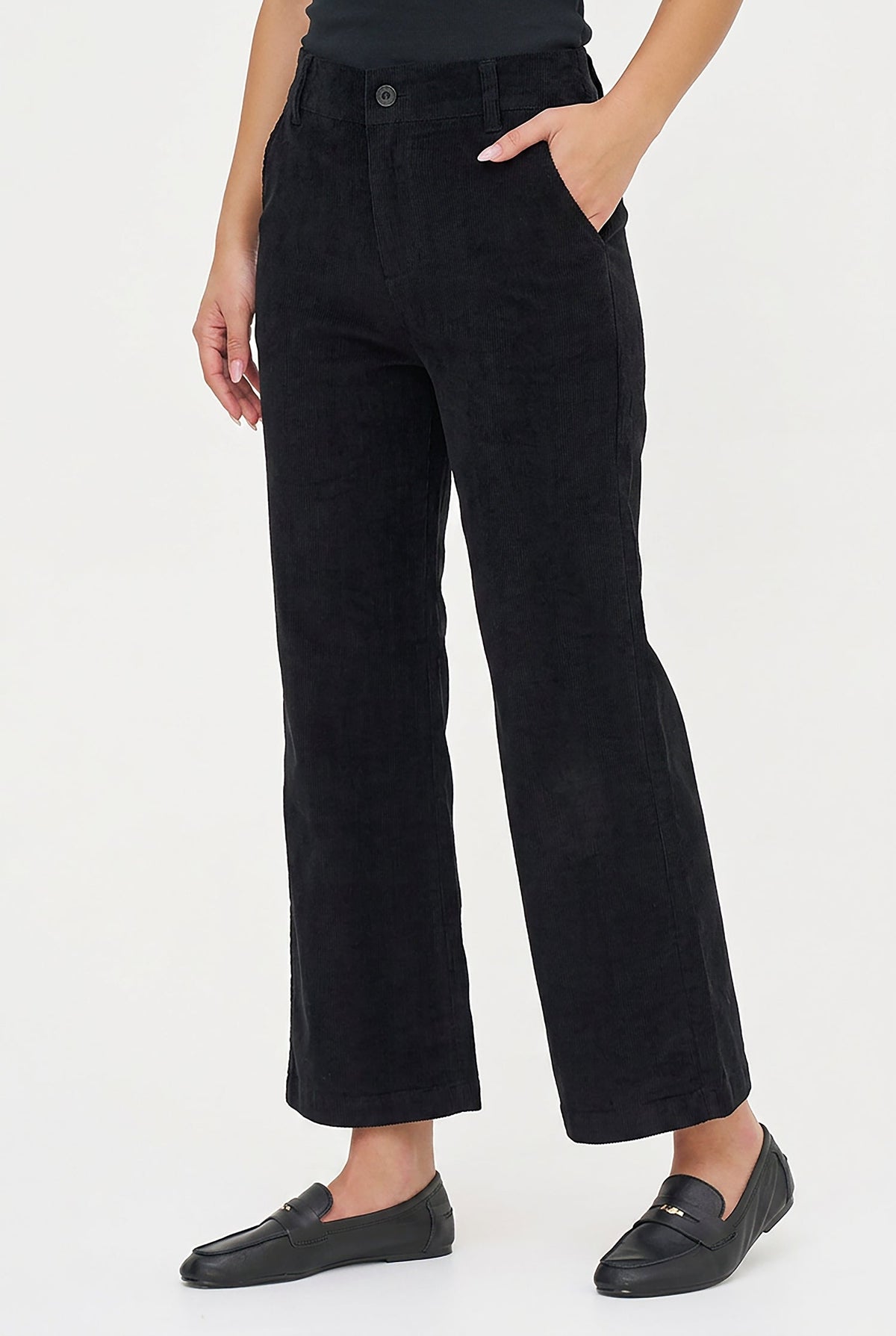 A model wearing black wide-leg cropped trousers, styled with a black top and black leather loafers, against a plain white studio background.