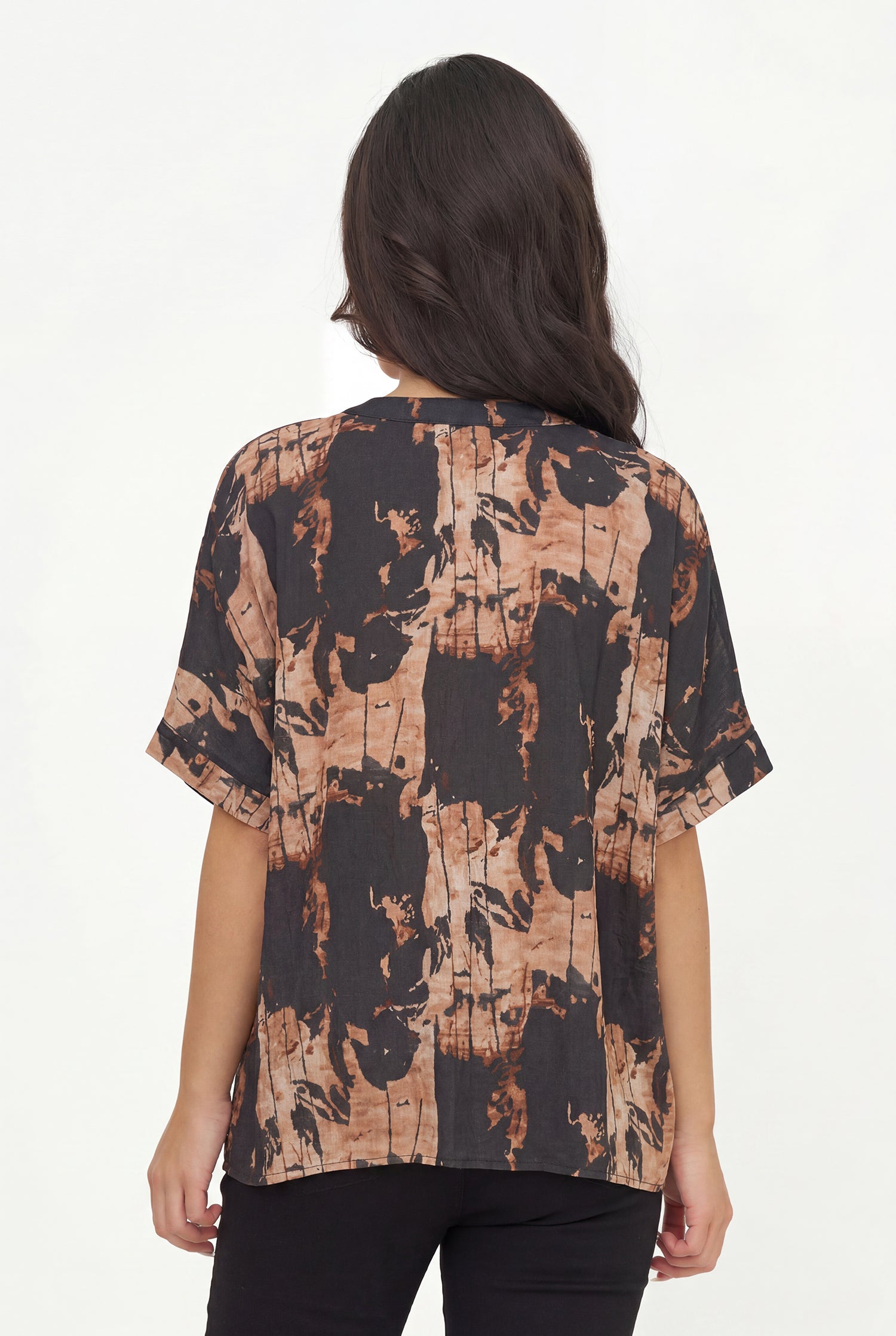 Woman wearing a patterned blouse with a white background