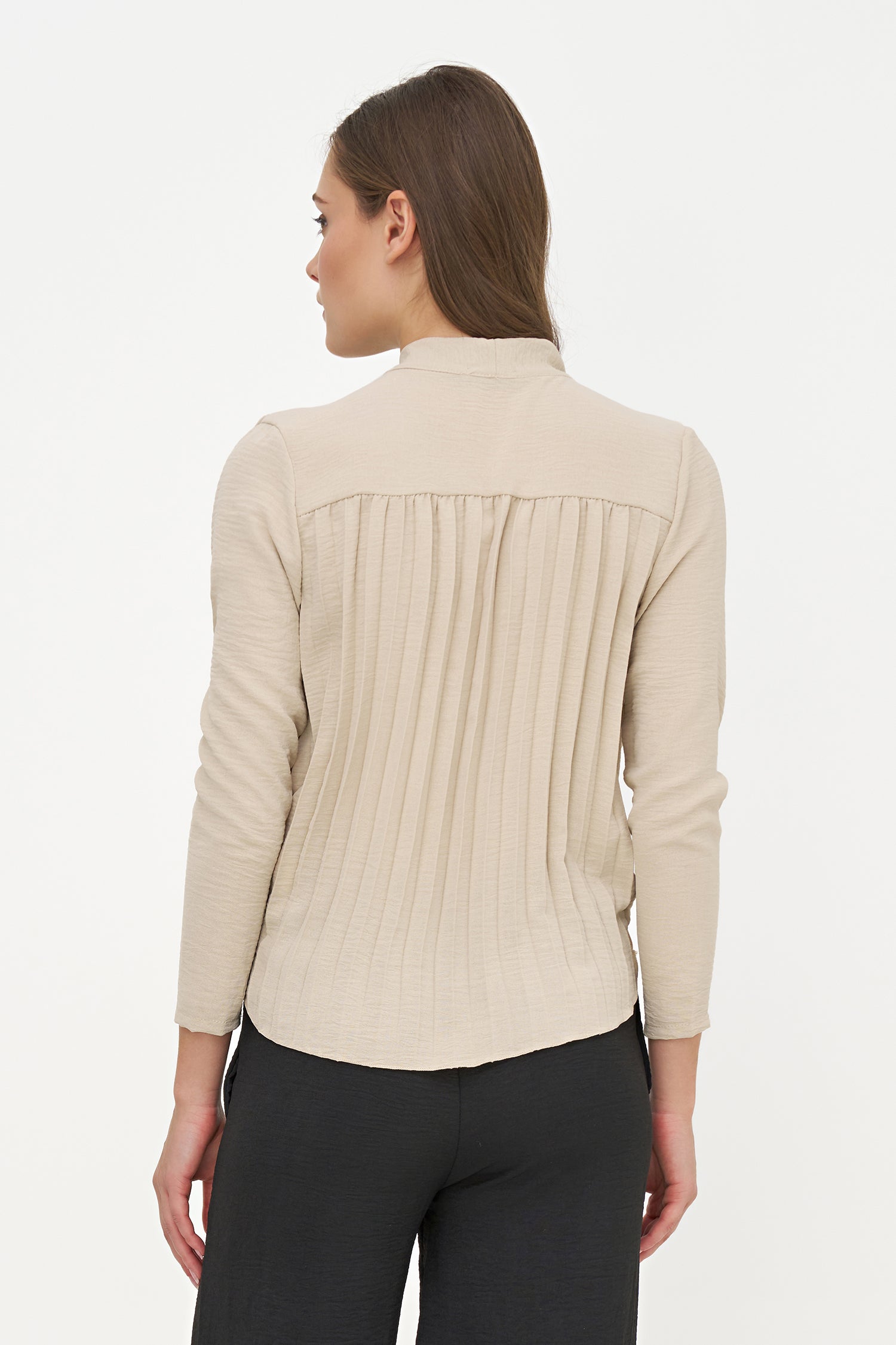 Woman wearing a beige long-sleeve shirt on a white background