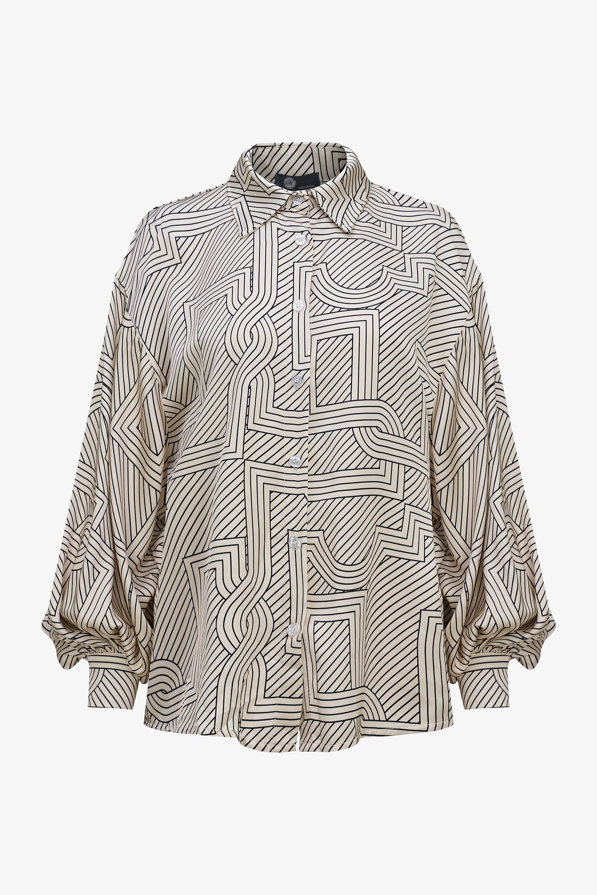 A long-sleeve button-up shirt with an abstract geometric maze-like line pattern in black on a warm beige background, shown against a plain light gray studio background.