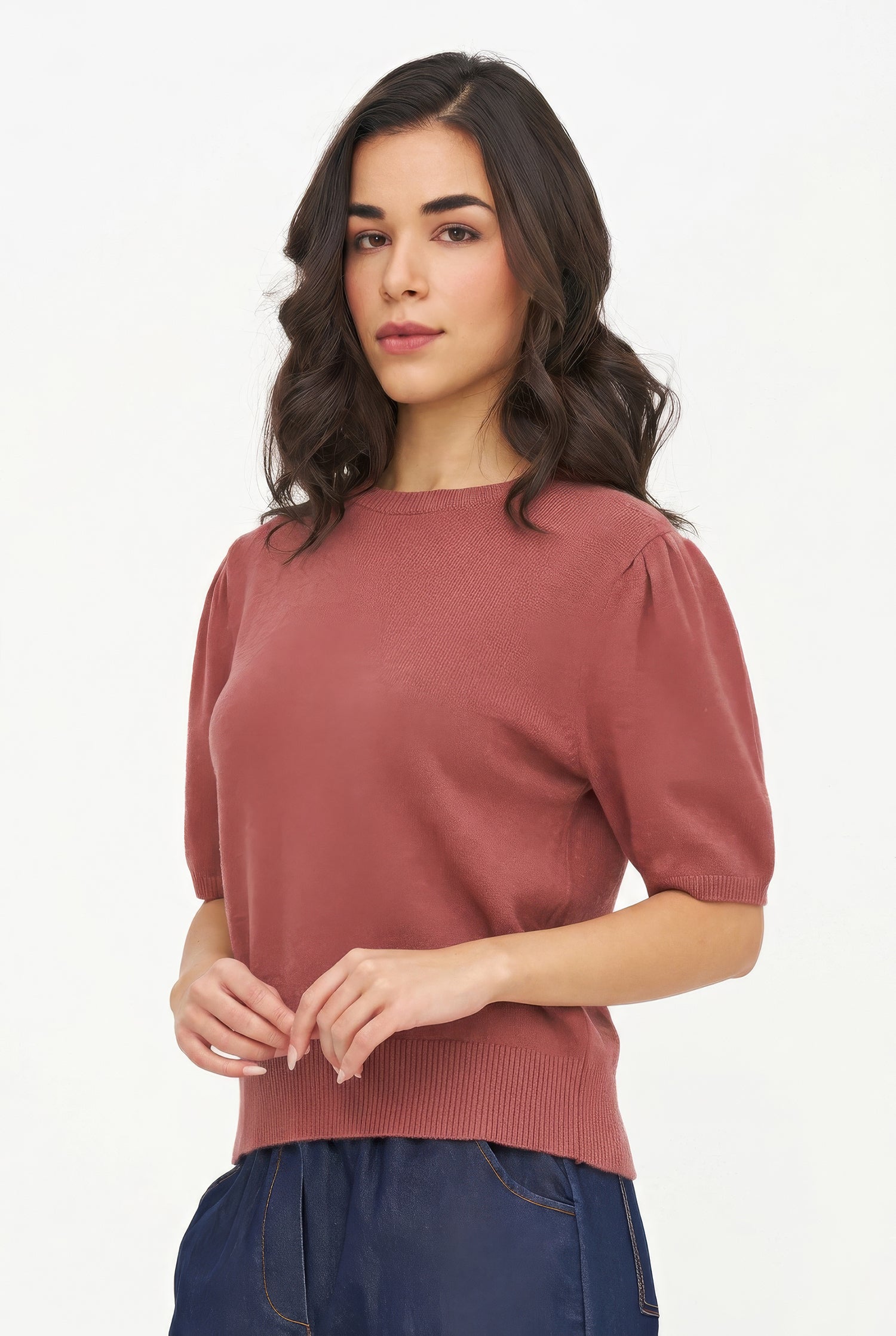 Woman wearing a rust-colored sweater against a white background