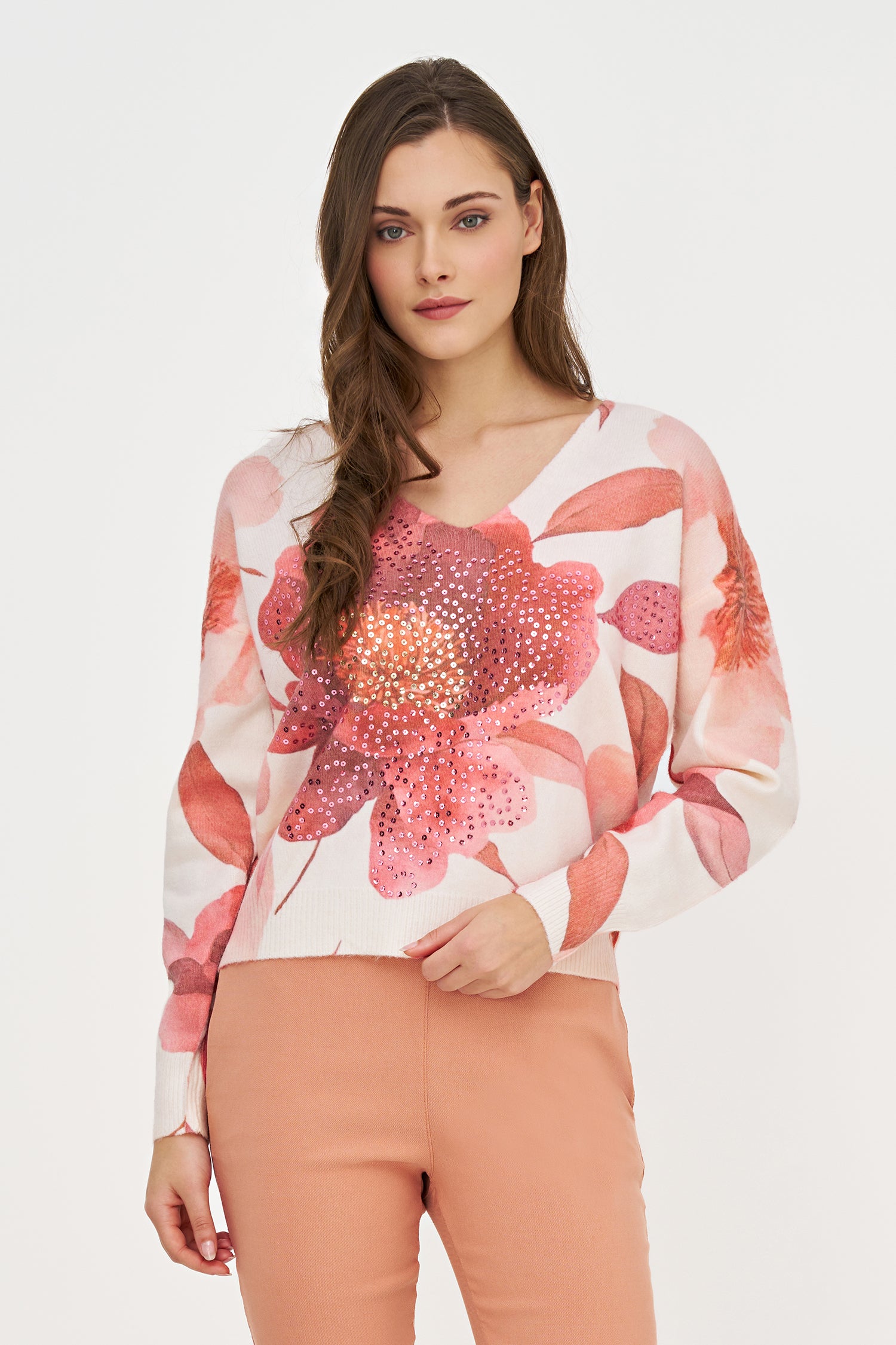 Woman wearing a floral blouse with sequins on a white background