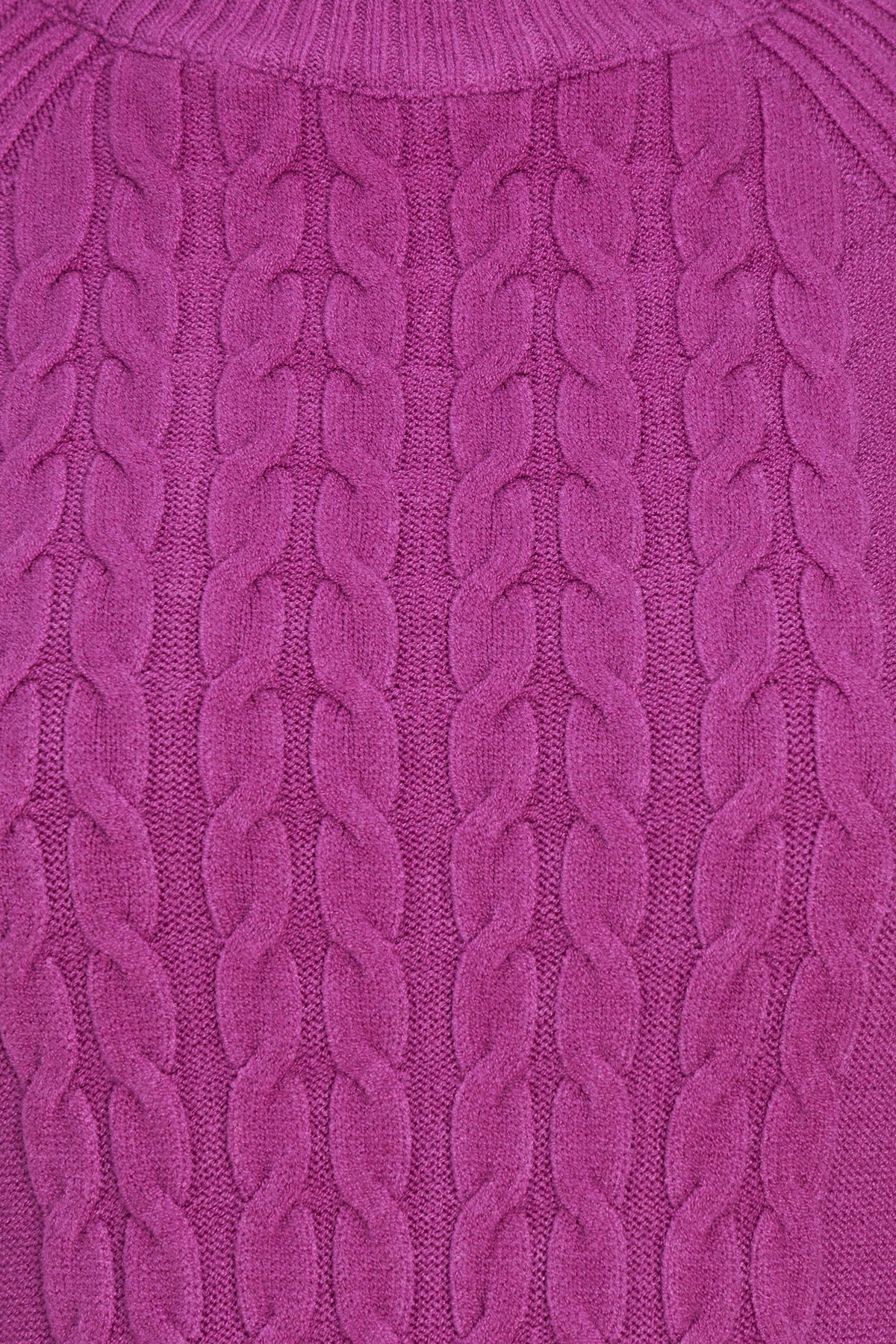 A close-up of a vibrant magenta cable-knit sweater showing the detailed knit pattern and texture.