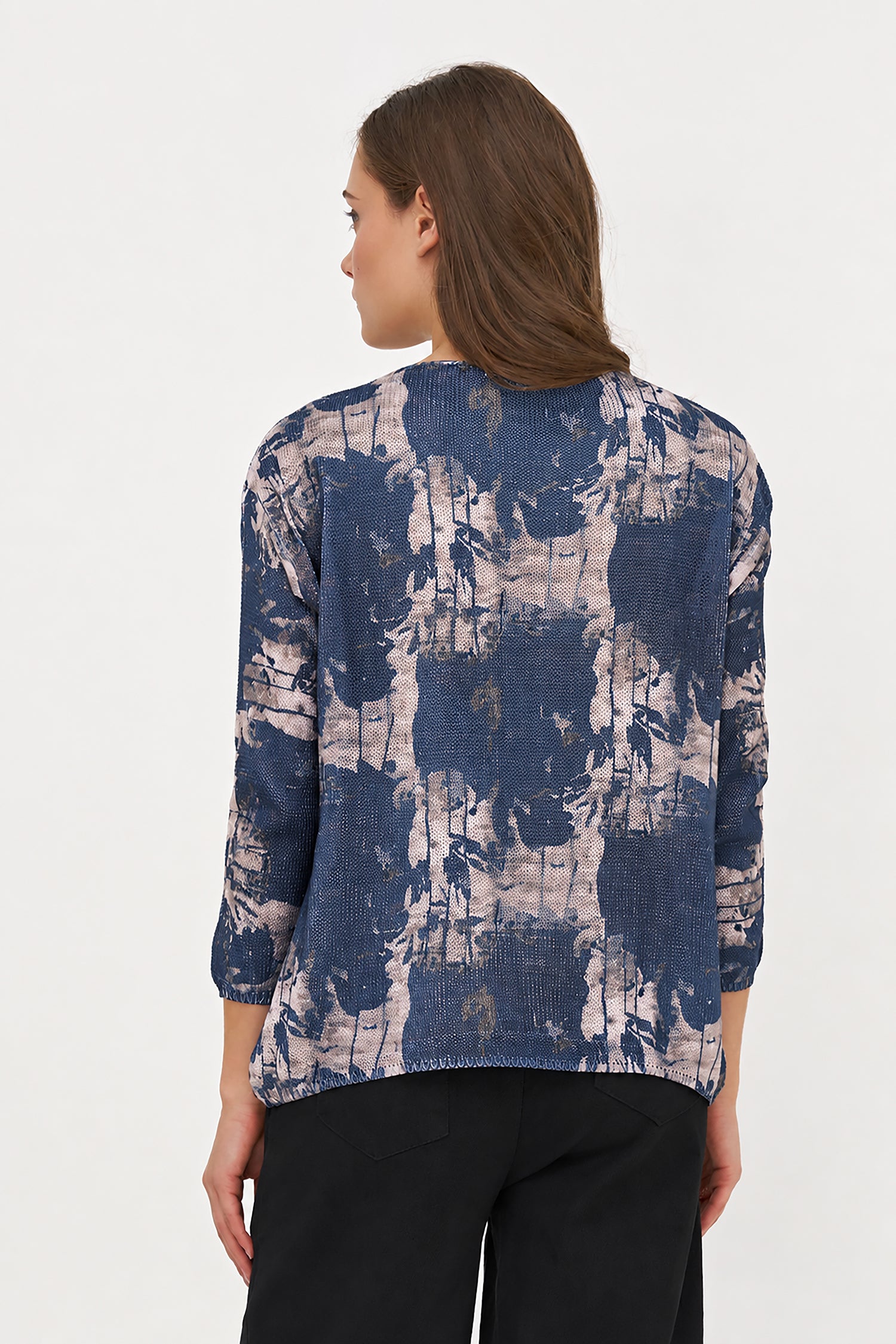 Woman wearing a blue and white patterned top on a white background