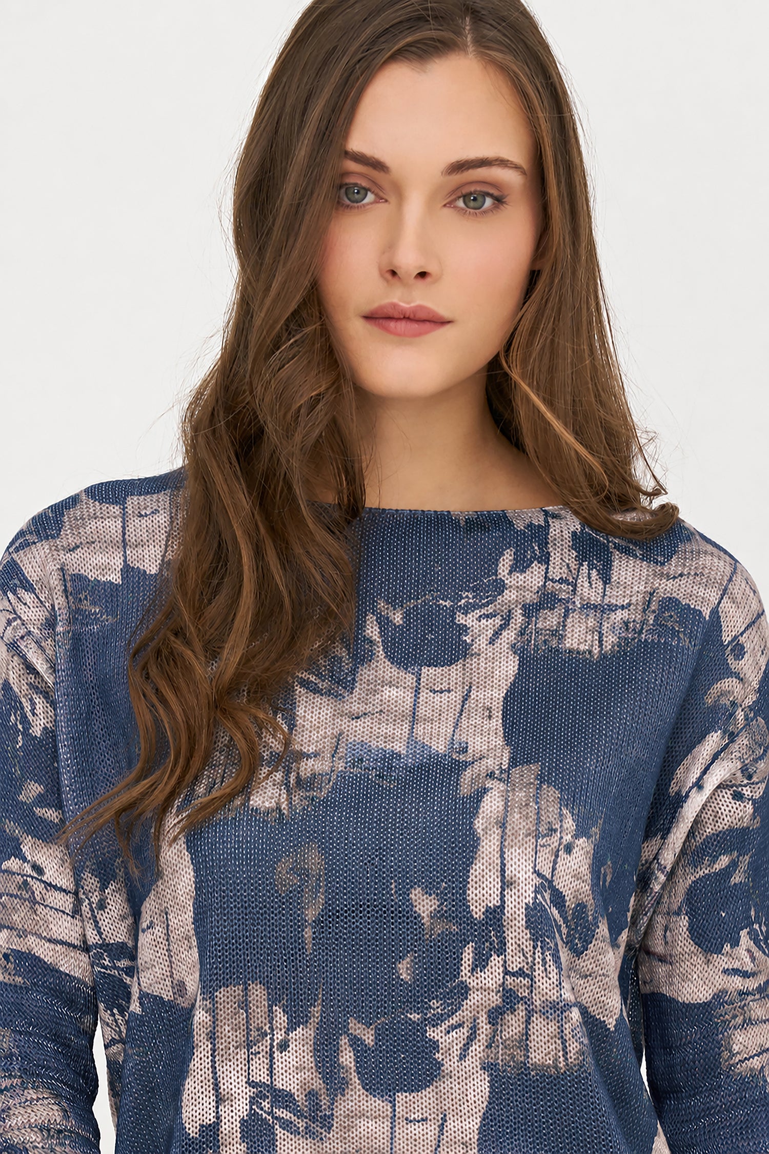 Woman wearing a blue and beige patterned sweater on a white background