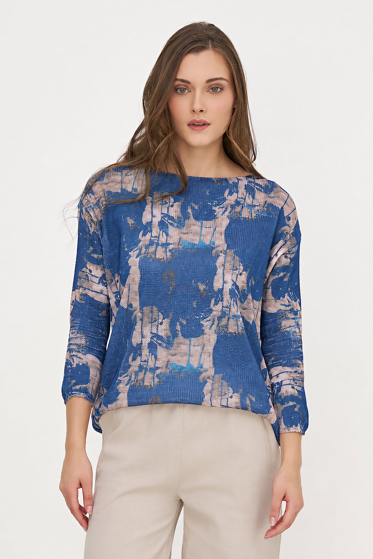 Woman wearing a blue and beige patterned top on a white background