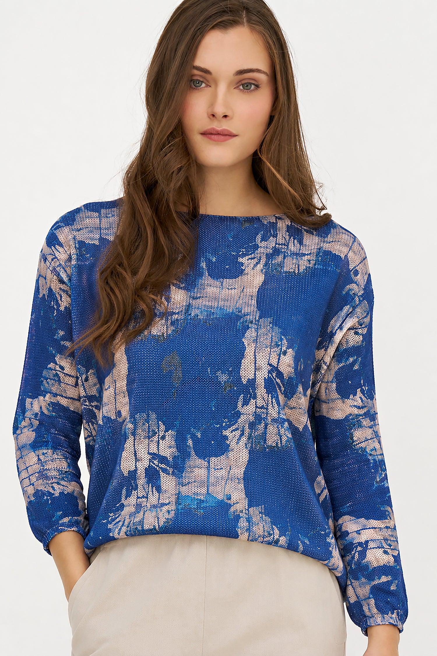 Woman wearing a blue and white patterned sweater on a plain background