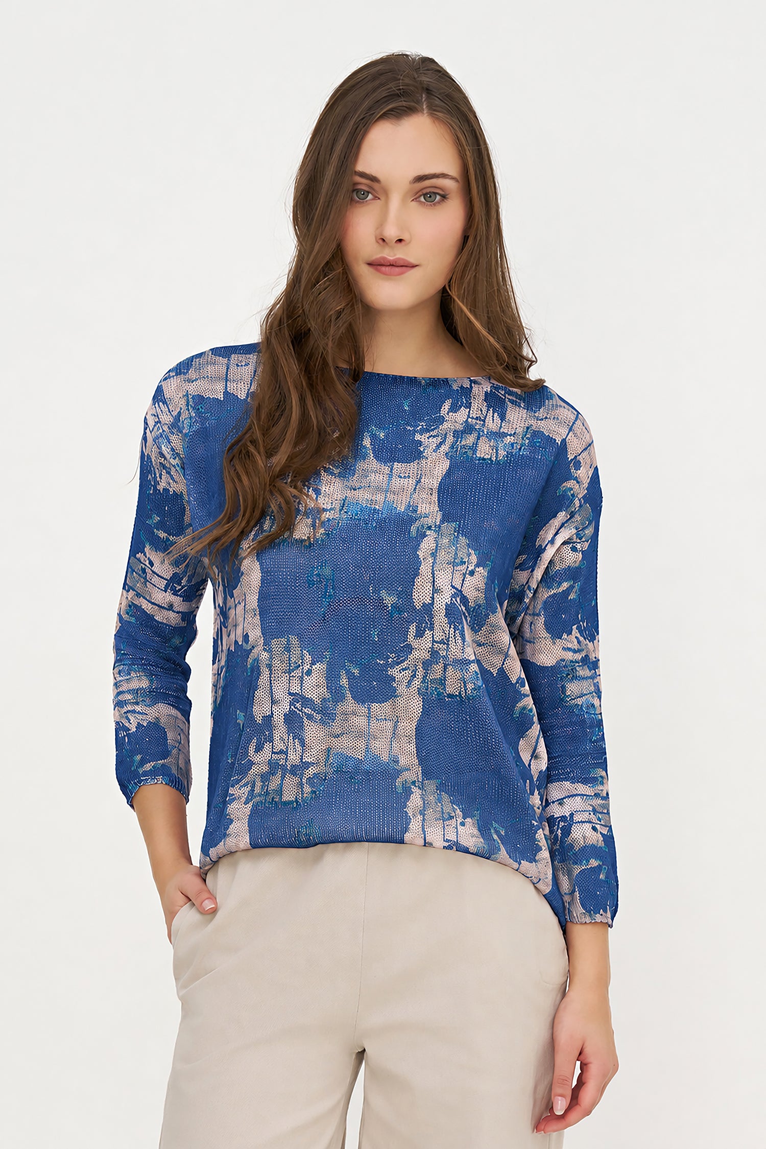 Woman wearing a blue and white patterned sweater on a white background