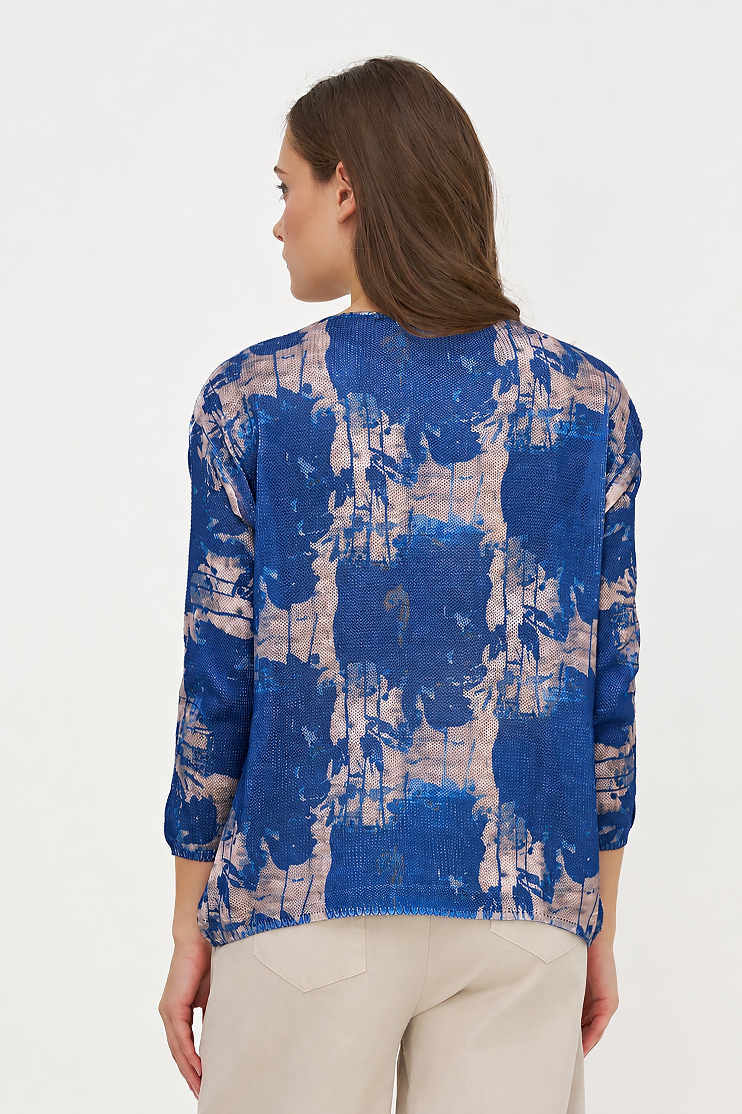 Woman wearing a blue and beige patterned top on a white background