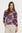 Woman wearing a purple patterned top on a white background