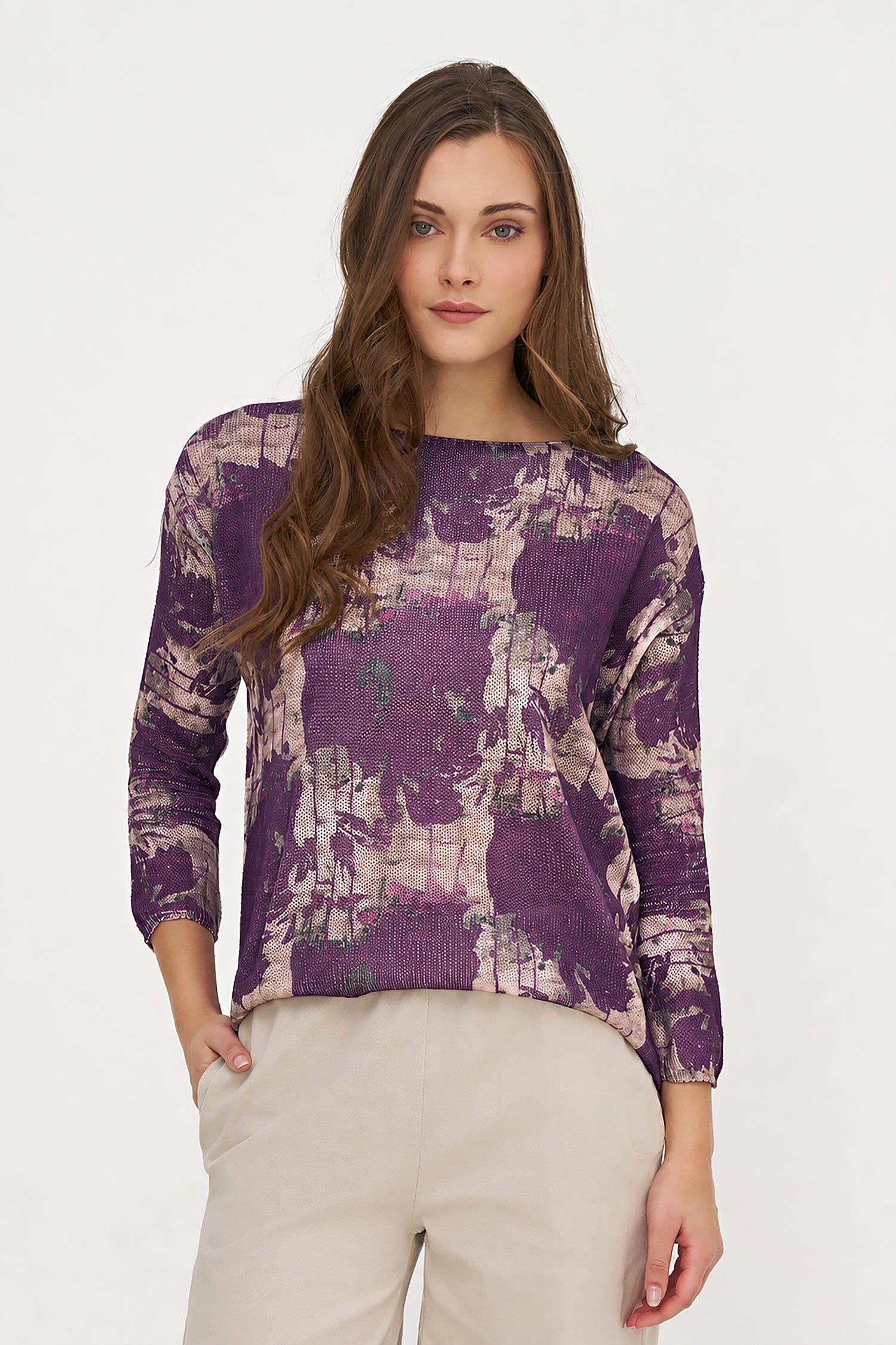 Woman wearing a purple patterned top on a white background