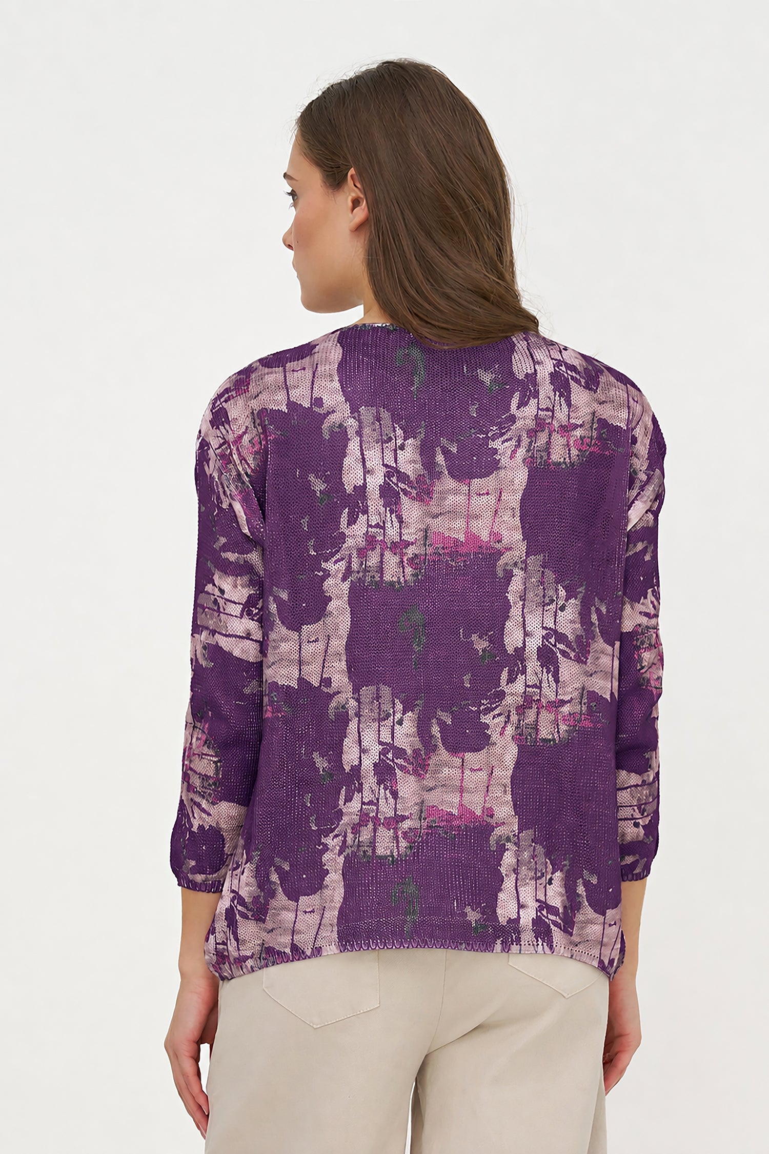 Woman wearing a purple patterned sweater on a white background
