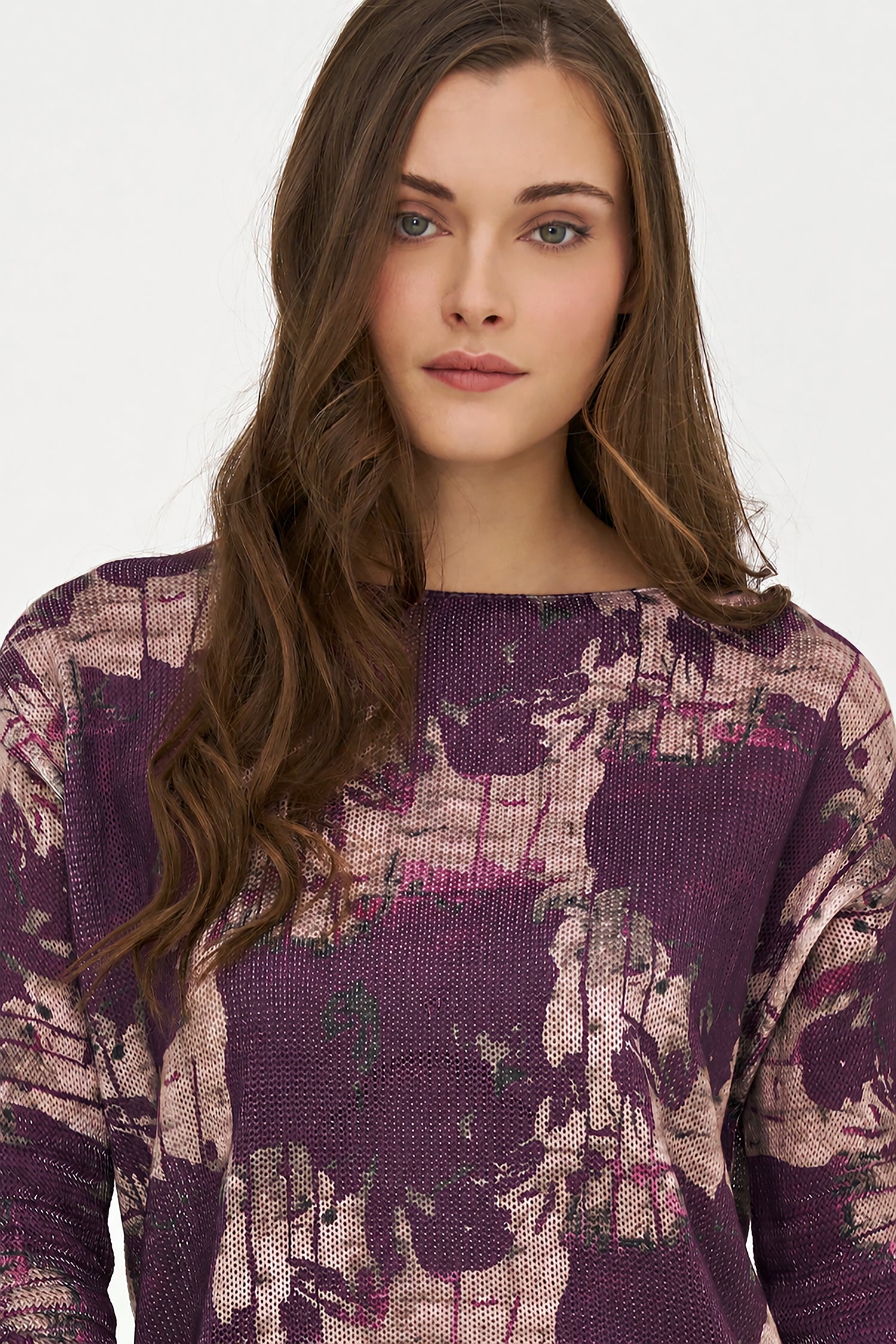 Woman wearing a purple patterned sweater against a white background