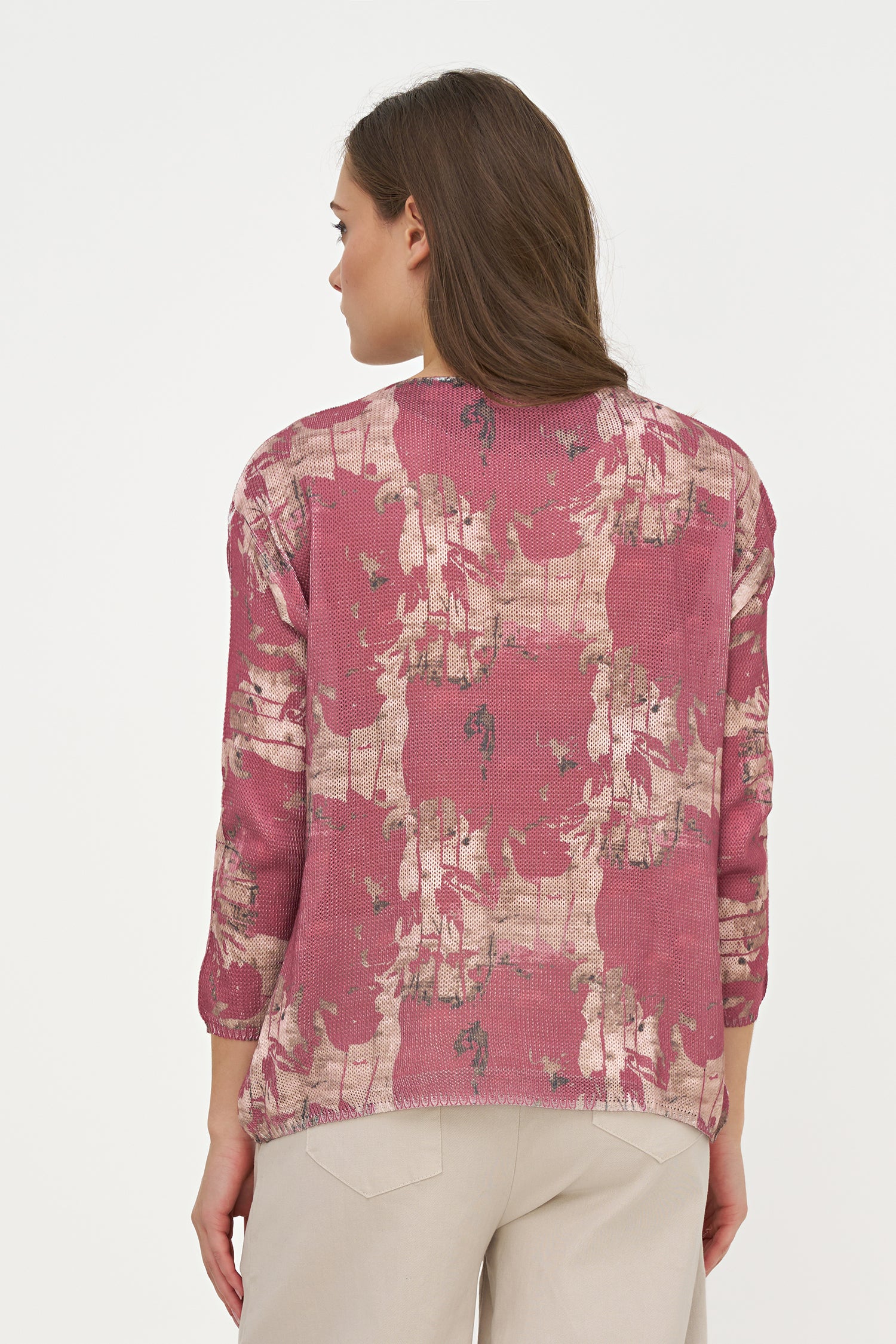 Woman wearing a pink floral blouse against a white background