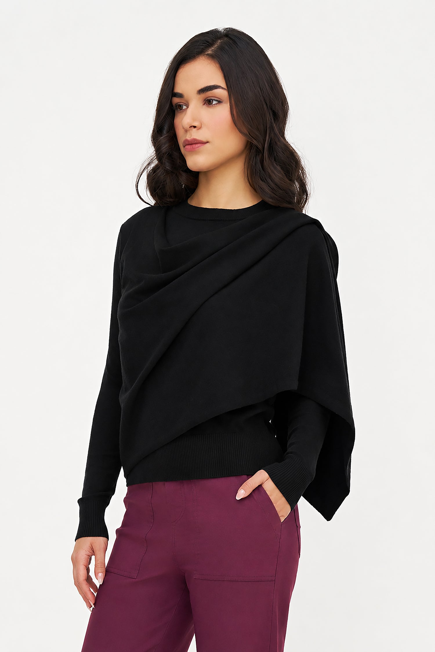 Woman wearing a black draped top and purple pants on a white background