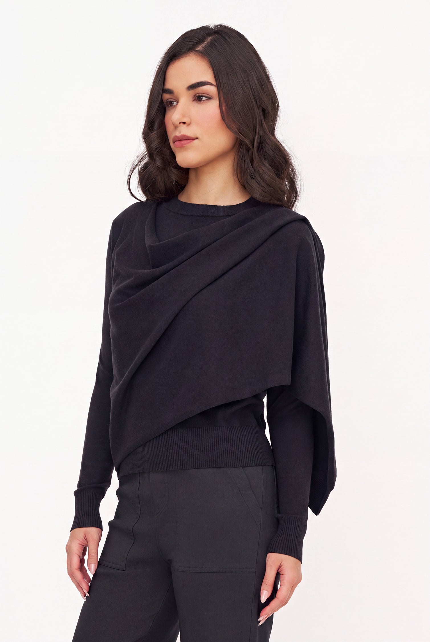 Woman wearing a black draped top and purple pants on a white background