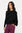 Woman wearing a black draped top and purple pants on a white background