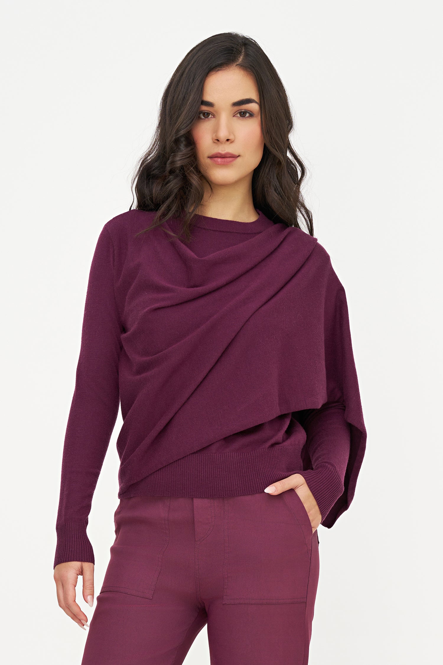 Woman wearing a purple outfit with a draped design on a white background