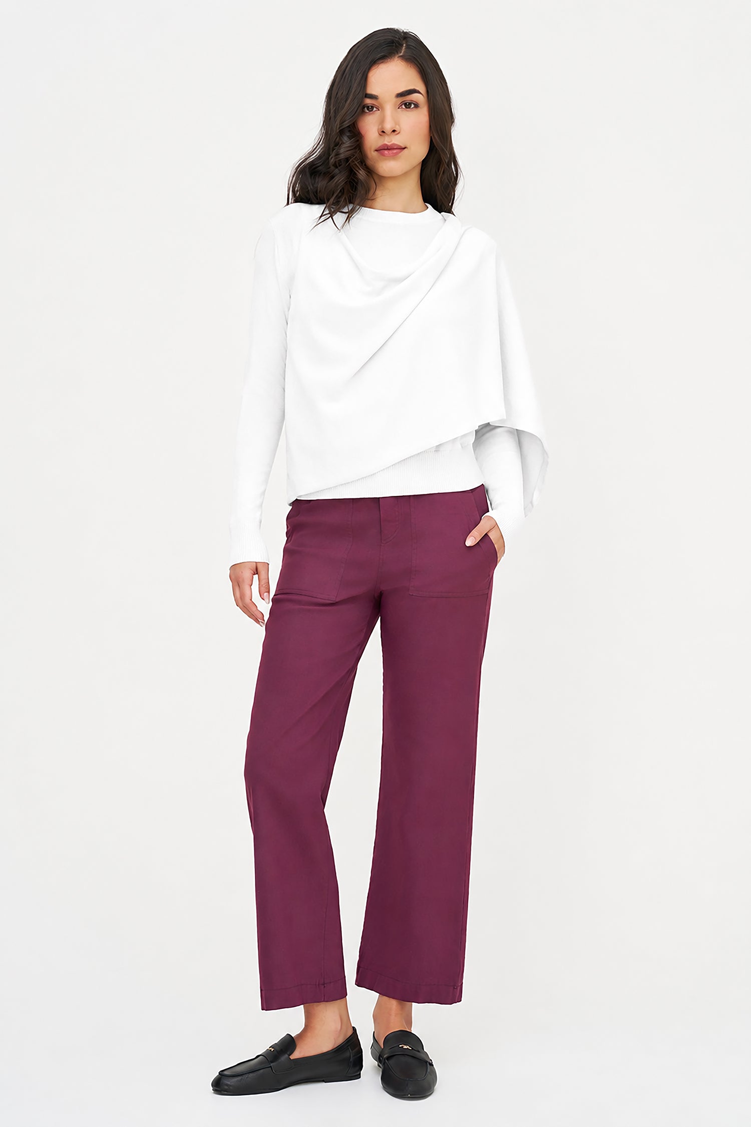 Woman wearing a white top and purple pants on a white background