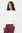 Woman wearing a white top and purple pants on a white background